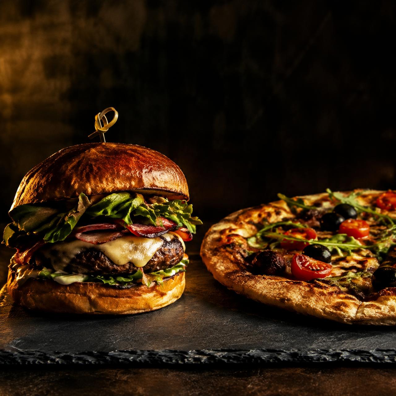 Hamburguesa gourmet y pizza artesana de SAUVAGGE sobre pizarra